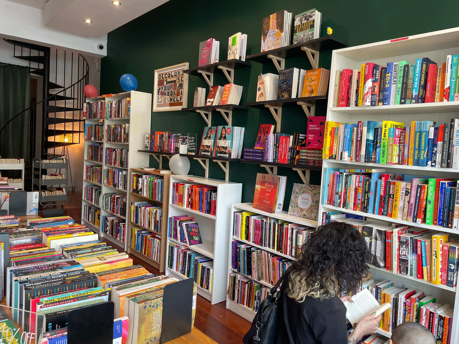 A photo of the inside of a booksthop. The walls and tables are filled with books.