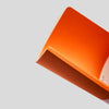 Close-up of an orange notebook on a light gray background