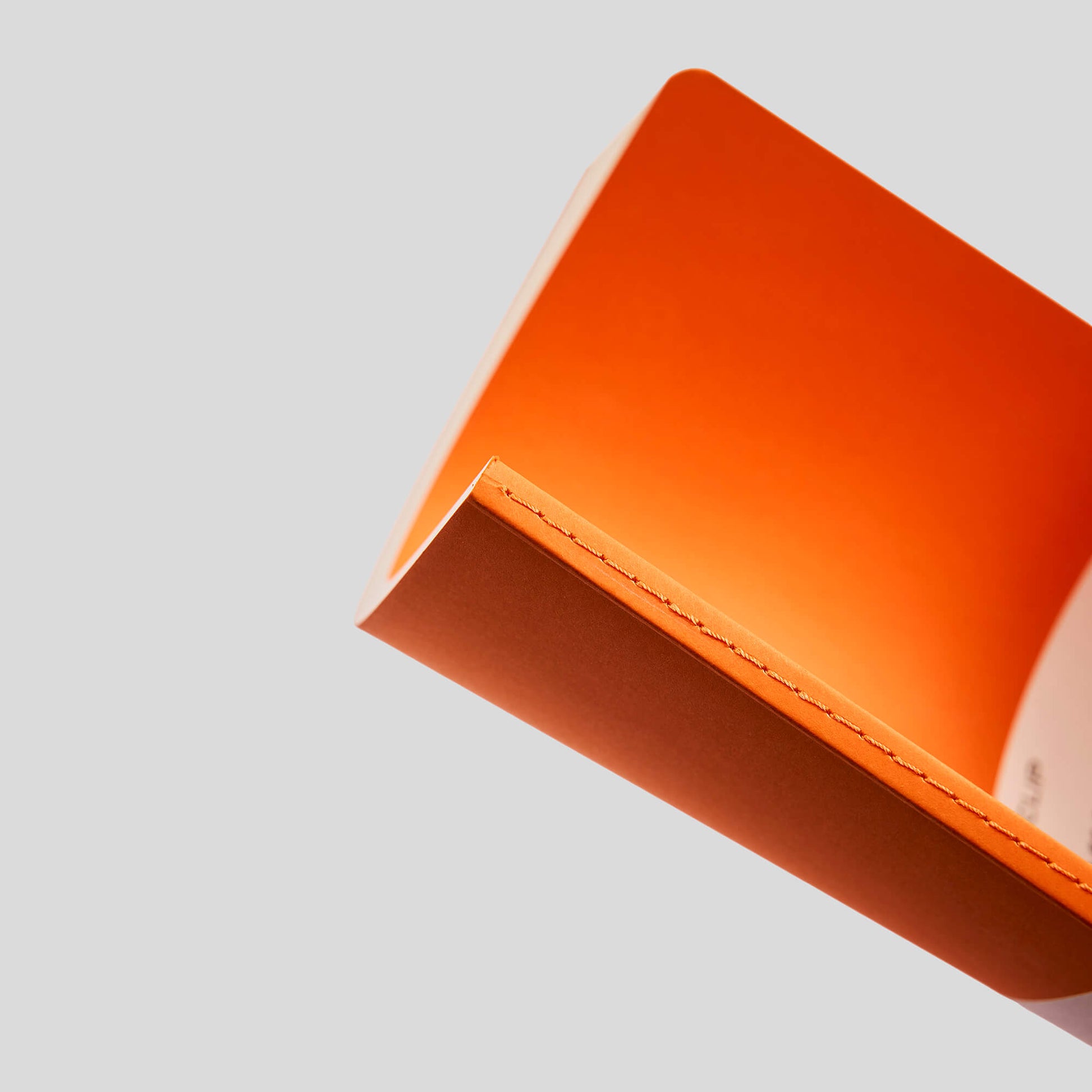 Close-up of an orange notebook on a light gray background