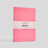 Pink notebook with a white label on a light gray background