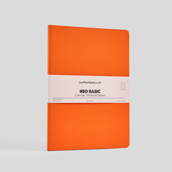 Orange notebook with a white myPaperclip bellyband, on a gray background