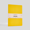 Yellow notebook with a beige label on a light gray background