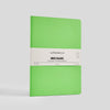 Green notebook with a white label on a light gray background